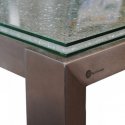 Detail foto van een RVS tafelonderstelmet glazen tafelblad